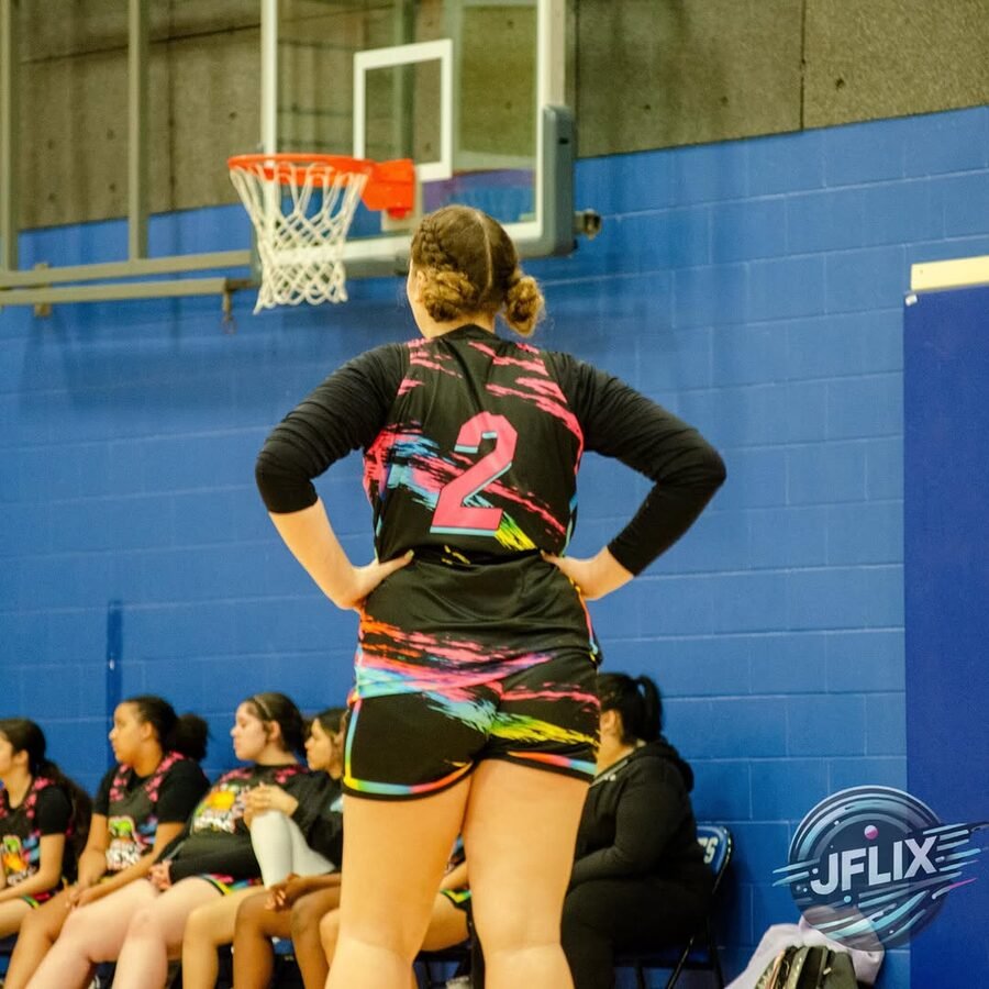 Vipers girls team player at the hoop with teammates on the bench